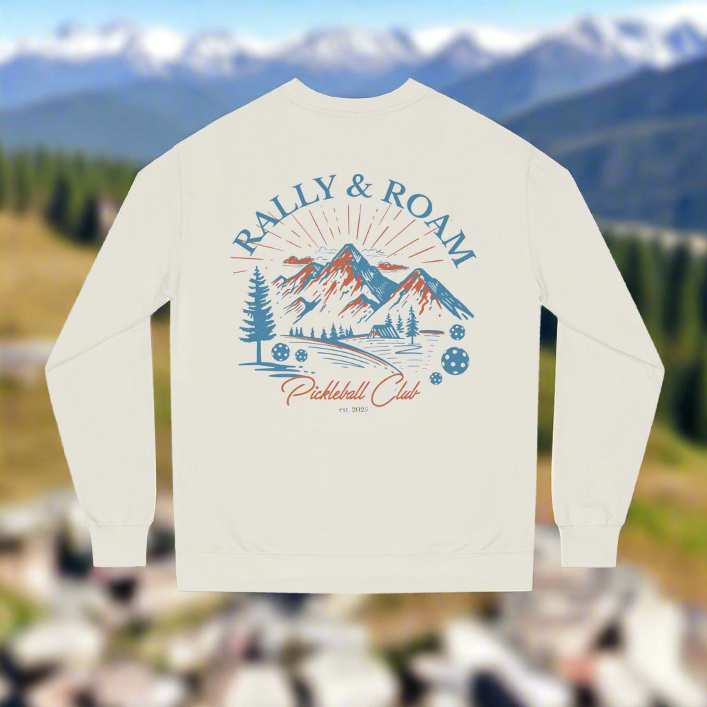 Beige sweatshirt with 'Rally & Roam' graphic design featuring mountains and trees on a white background.